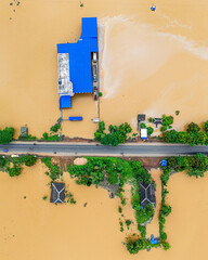 Fototapeta na wymiar Widespread flooding in rural area, aerial image of submerged village landscape.