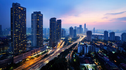 A bustling cityscape at dusk with tall buildings, a river, and a busy highway, illuminated by the glow of the setting sun.