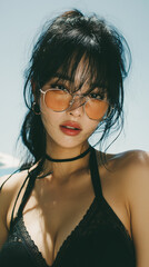 Woman in sunglasses enjoys sunny beach day while posing in swimwear during summer vacation