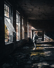 Explorer in an Abandoned Brick Building with Dramatic Lighting
