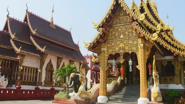 Chiang Mai, Thailand - 16th march, 2024: panning view Ornate Wat Saen Mueang Ma Luang Buddhist temple in Chiang Mai with golden facade, mythical statues, rich Lanna design