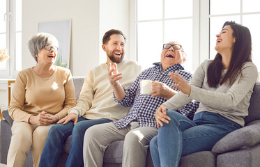 Happy family with elderly parents and grown children enjoying leisure time, talking together on the...