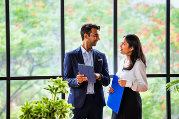 Chasing project deadline indoors, Indian corporate team discusses work using tablet in office