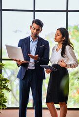 Walking indoors celebrating with laptop, Indian business team cheers with energy and confidence