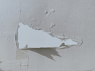 Close up of white paint is peeling off the wall. Failure of coating to properly adhere to surface....