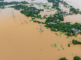 Aerial perspective of natural disaster—flooded homes and brown water spreading wide.