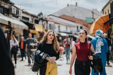 Two friends walk through a lively urban street filled with people and shops, enjoying their outing...