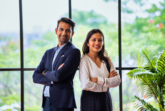 Posing with success and smiling confidently, Indian business professionals stand in office together