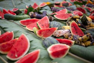 selective focus  Watermelon slices covered with banana leaves with various fruits. Elephant food at...