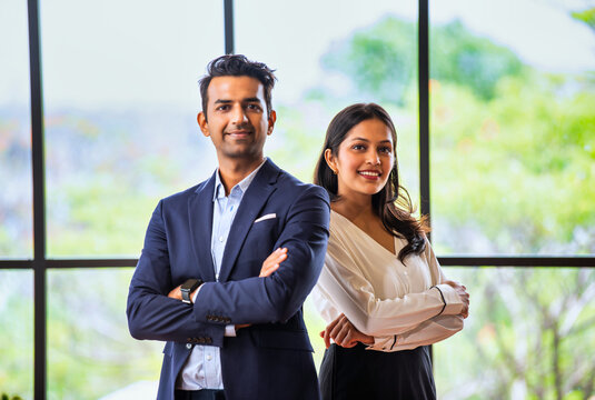 Posing with success and smiling confidently, Indian business professionals stand in office together