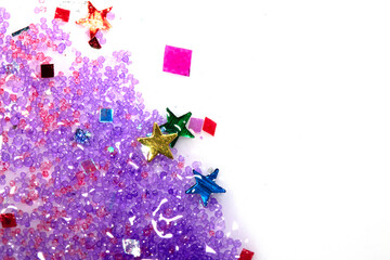 Close up of confetti tinsel glitter and shining stars on white background