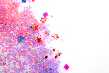 Close up of confetti tinsel glitter and shining stars on white background