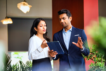Chasing project deadline indoors, Indian corporate team discusses work using tablet in office