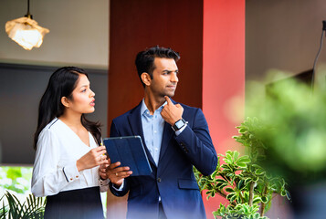 Chasing project deadline indoors, Indian corporate team discusses work using tablet in office