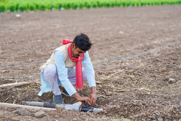 young indian farmer working in agricultural field