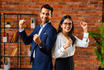 Fototapeta na wymiar Posing with success and smiling confidently, Indian business professionals stand in office together
