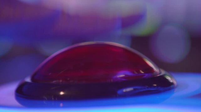 Pressing large red button at arcade game close up 4k