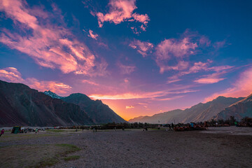 A breathtaking sunset across a dramatic mountain valley. The serene landscape is enriched by...