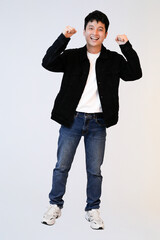 excited young asian man celebrate in studio background