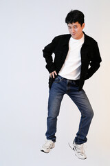 playful young asian man winking and posing in studio background