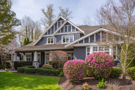 Two story stucco luxury house with nice spring blossom landscape in Vancouver, Canada, North America. Day time on June 2025.
