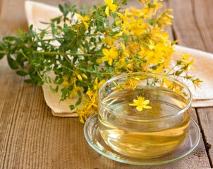 Herbal tea from Hypericum perforatum commonly known as St John's wort. Drink with fresh flowers on the wood table. Traditional herbal medicine.