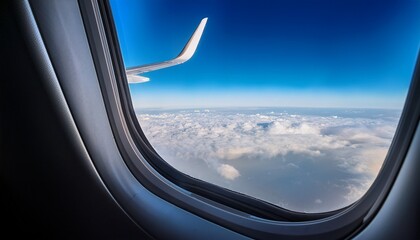 Naklejka premium looking through a big jet passenger plane window above the clouds
