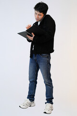young asian man on phone while holding book in studio background