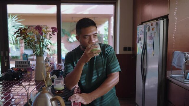 Relaxed scenes of man sipping homemade matcha latte at home. Natural lifestyle moments showing calmness, daily ritual, and enjoyment of a traditional green tea drink.