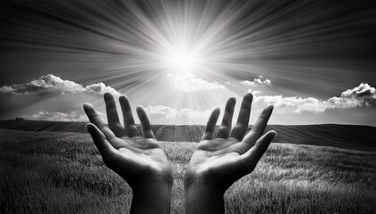 open hands reaching to the sky sun rays black and white
