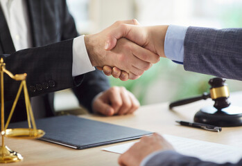 Lawyer or attorney shakes hand with client during office meeting, focusing on collaboration and...