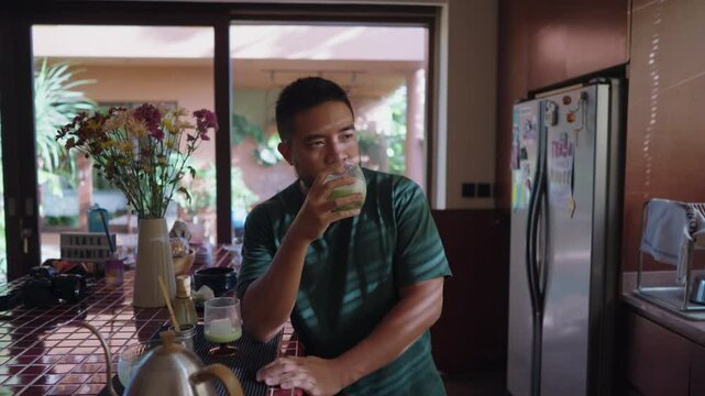 Relaxed scenes of man sipping homemade matcha latte at home. Natural lifestyle moments showing calmness, daily ritual, and enjoyment of a traditional green tea drink.