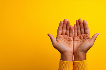 Open Hands Showing Palms Up Against A Bright Yellow Background