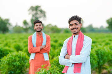 indian farmer standing together at green agricultural field