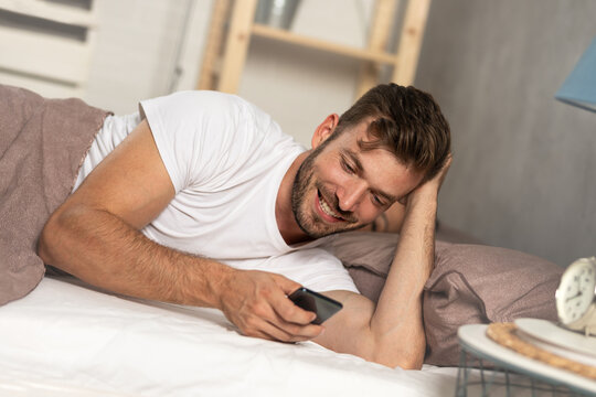 Smiling young man flirting over the phone