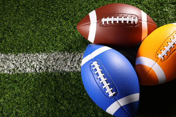 American football balls, rugby balls, different colours on grass and black backgrounds