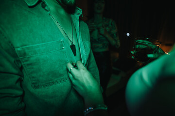 A close-up image captures friends at a party, highlighting the tactile connection and lively...