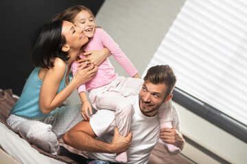 Young family having fun in   bed