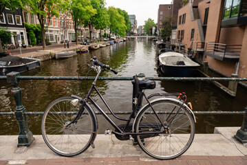 Obraz premium Classic Dutch bicycle parked on a bridge over a canal in Amsterdam