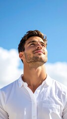 Skyward Gaze: A handsome man, bathed in natural light, gazes skyward with hopeful and positive aspirations under the vast canvas of a bright blue sky, embodying hope and aspiration.