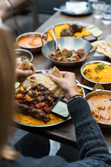 Woman tearing naan bread at an Indian restaurant in Australia