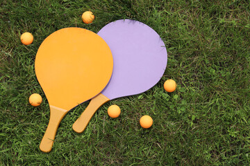 Beach tennis rackets and ball on grass, top view. Active lifestyle, games and sports. Beach tennis...