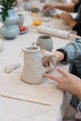 Clay hand building workshop woman shaping a jug