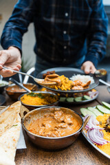 Man spooning curry on to his plate at an Indian Restaurant in Australia