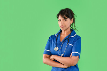 Healthcare professional in blue scrubs poses confidently against a bright green background during a...