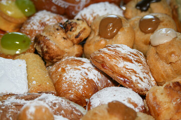 Assortment of sweet cakes with cream and powdered sugar.