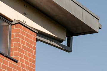 Rain gutter downspout draining rainwater from roof into drainpipe