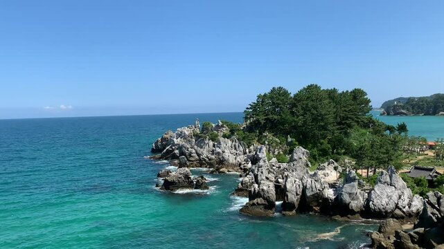 Chuam Chotdaebawi Rock and nearby rocks formations. Motion of East sea waves. Famous sightseeing place. Sol Beach Hotel in the background. Donghae, South Korea