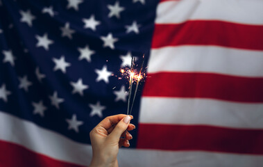 Woman holding Sparklers on American Flag background. Independence day United States. Celebration...