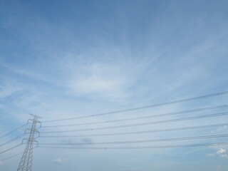 Power Tower and Electric Wires Under Blue Sky with Wispy Clouds.